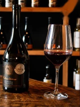 Taça de vinho tinto ao lado da garrafa